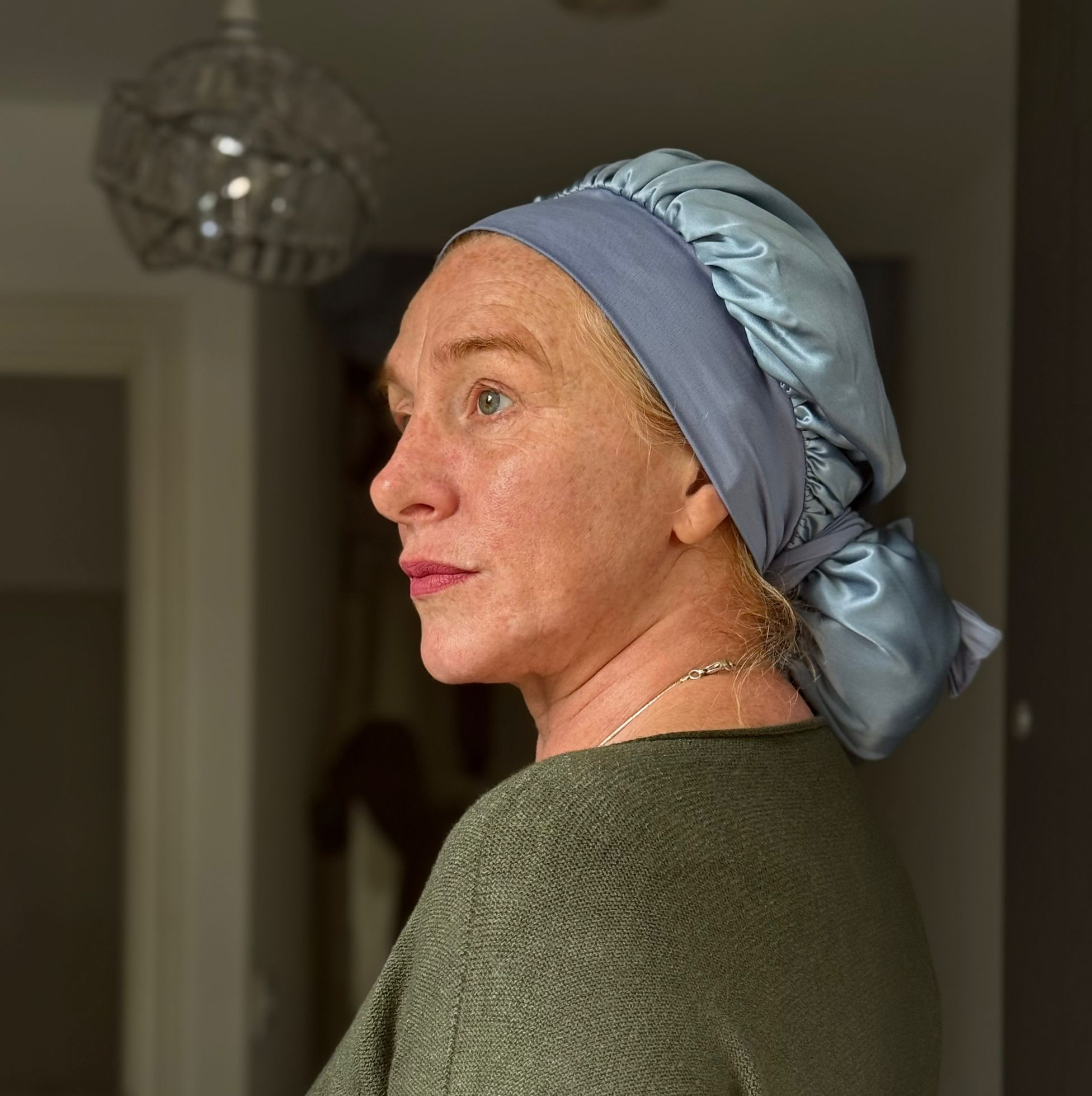 woman in her 60s wearing a light blue mulberry silk bonnet side profile healing her hair naturally